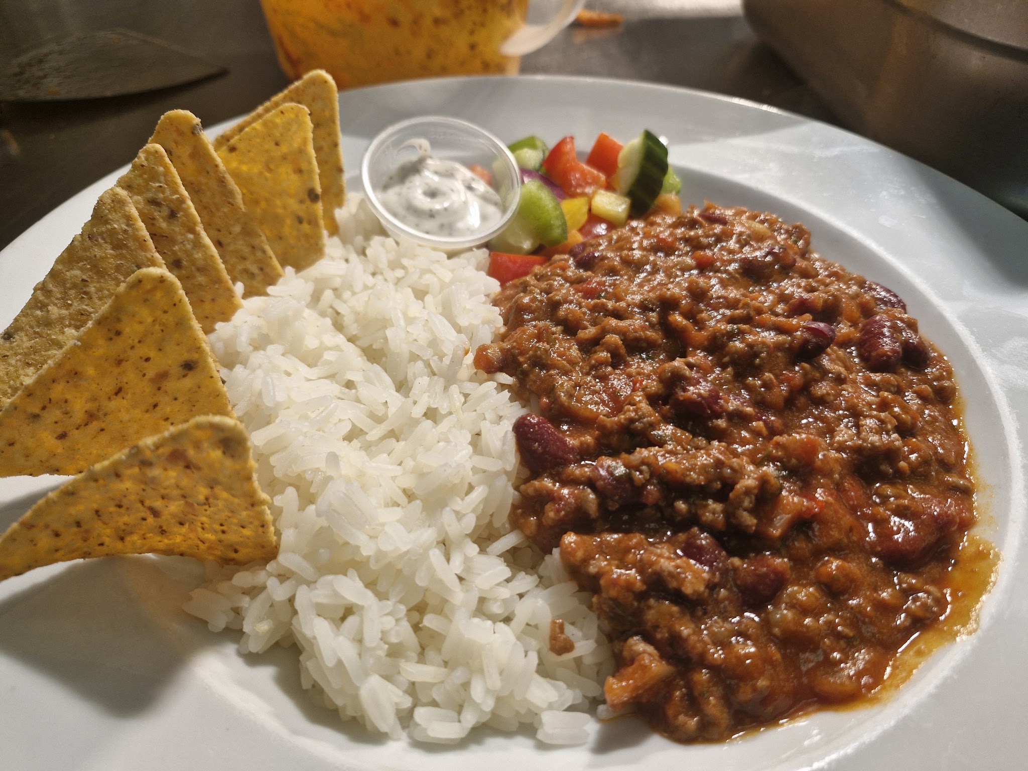 Chilli con carne with rice, tortilla chips, a little salad and sour cream
