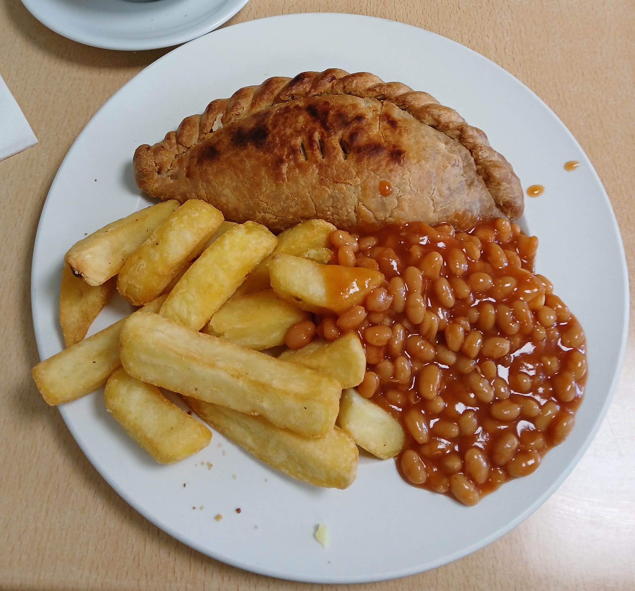 A golden Cornish pasty with chunky chips and baked beans